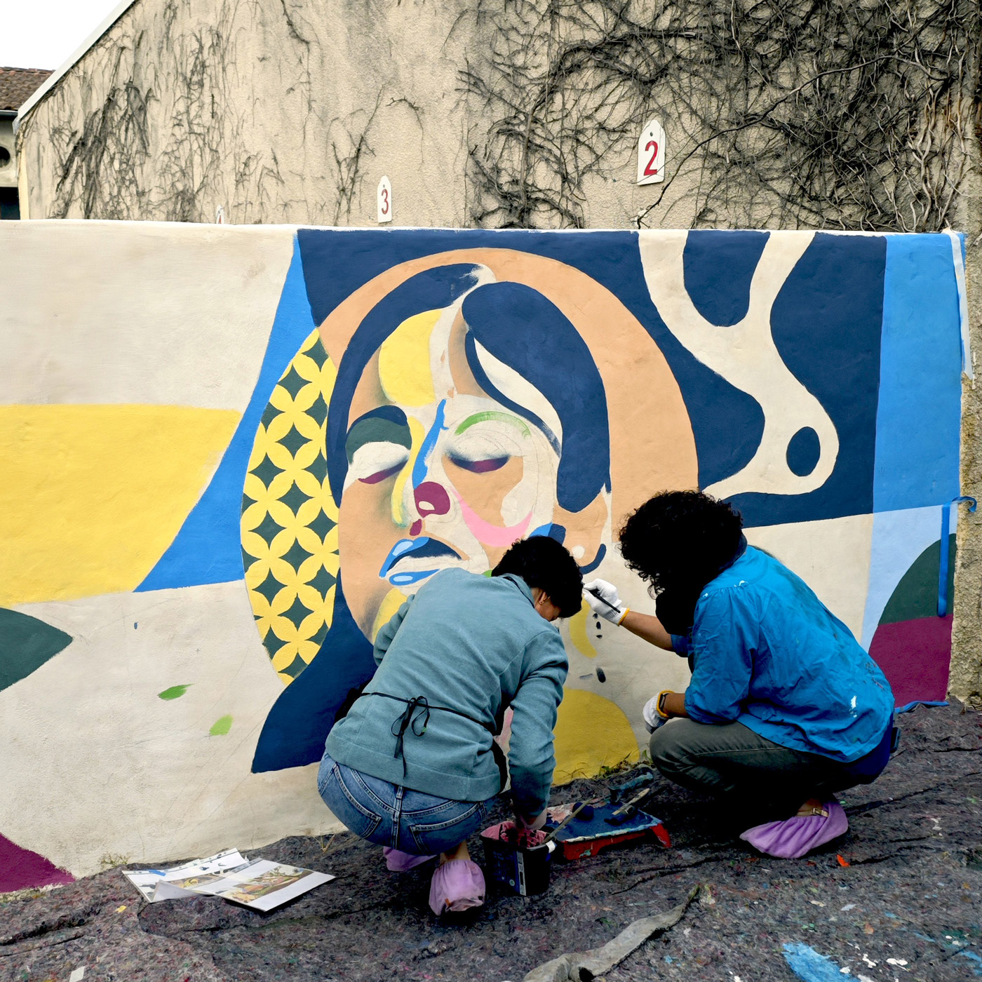 Les bénévoles et les bénéficiaires du centre à l'œuvre devant la peinture